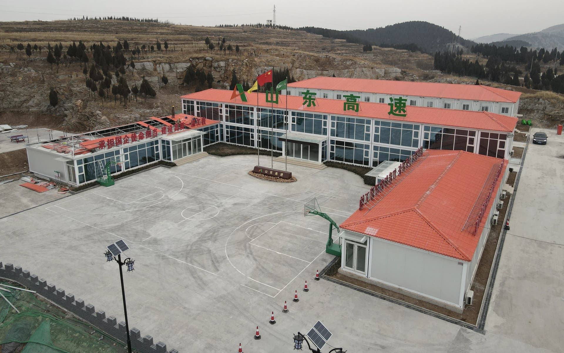 Aerial photograph of modular camp buildings around a shared courtyard