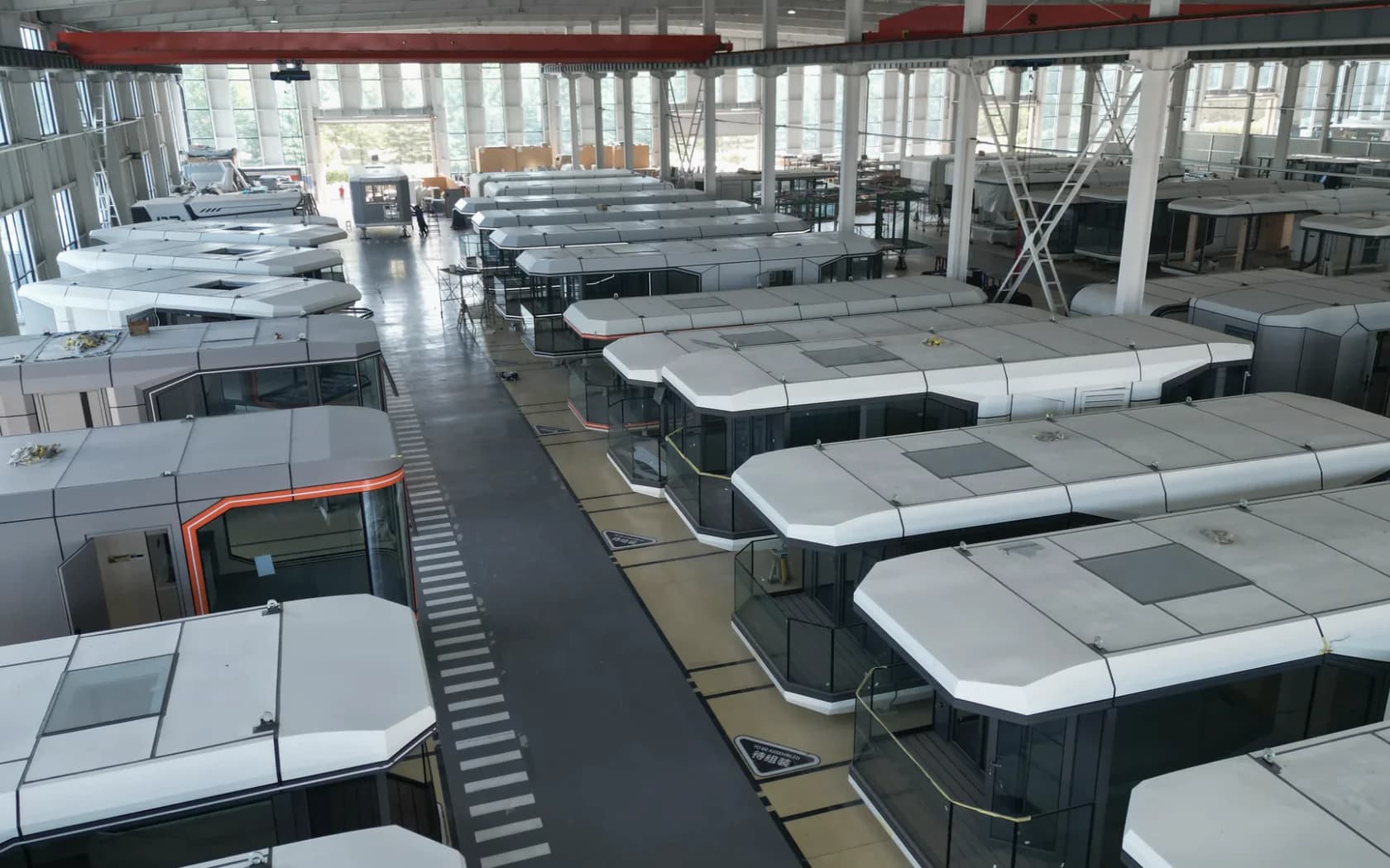 Space-capsule modules arranged inside a production hall
